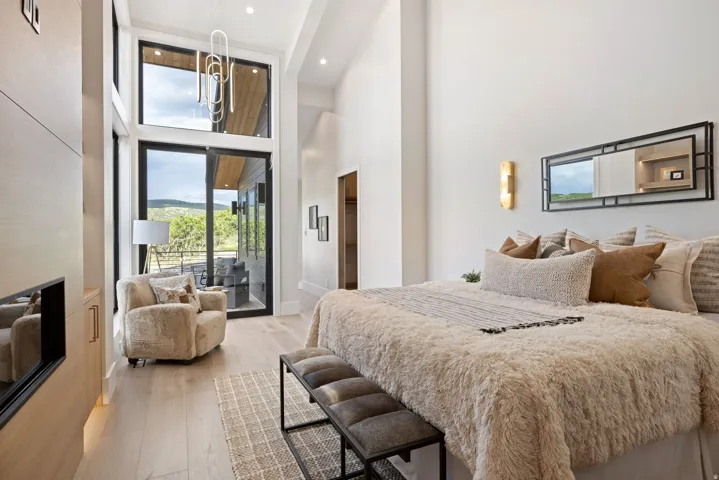 Expansive room featuring high ceilings, light wood-finish flooring, and a large sliding glass door