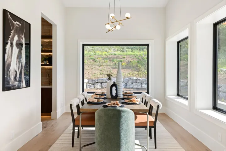 Dining area featuring wood-finish flooring, a modern linear chandelier, and expansive windows