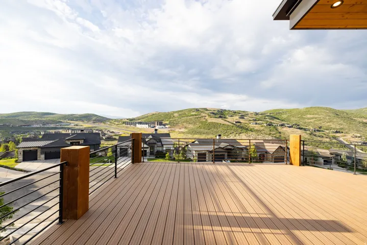 Expansive outdoor deck featuring wood-finish composite decking and modern metal cable railing