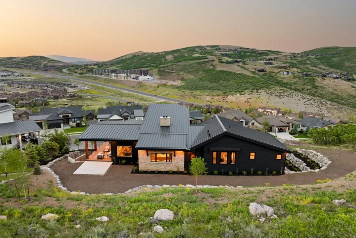 Modern exterior featuring a dark facade, stone accents, and a metal roof