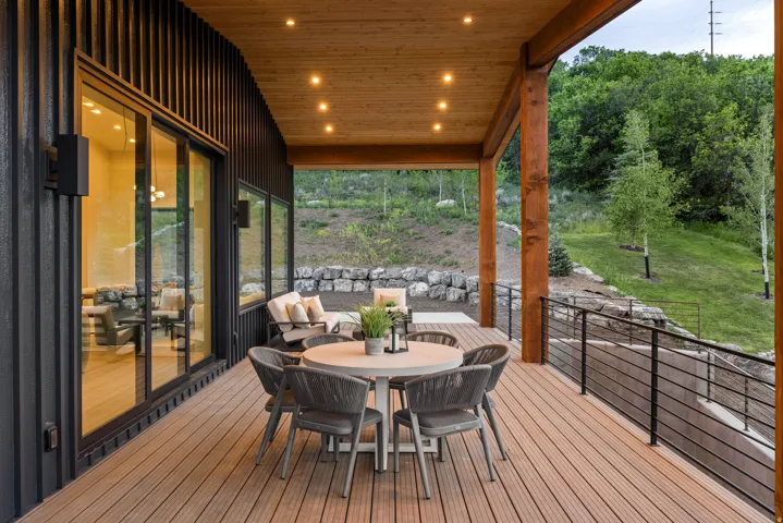 Expansive outdoor deck featuring wood-finish flooring, a wood plank ceiling with recessed lighting, and robust wood support beams