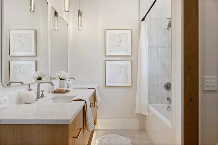 Bathroom featuring a double vanity with stone countertops, undermount sinks, and contemporary brushed nickel faucets