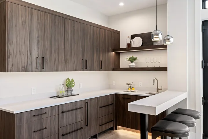 Modern bar area featuring wood-finish cabinetry and white countertops
