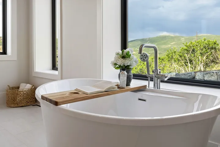 Freestanding soaking tub with a contemporary chrome floor-mounted faucet