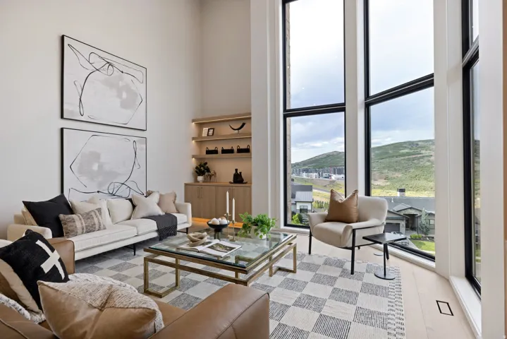 Vaulted ceilings complement the floor-to-ceiling windows, showcasing the expansive mountain and neighborhood scenery
