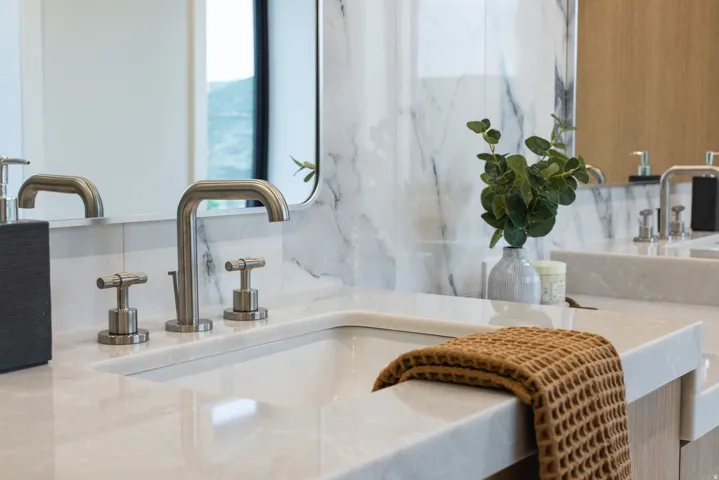 Dual vanity featuring integrated sinks, light-toned stone countertops, and brushed nickel fixtures