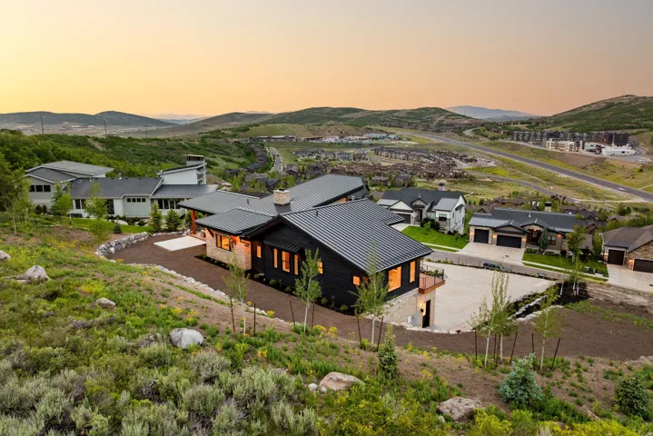Contemporary residence featuring dark vertical siding and light-toned stone accents