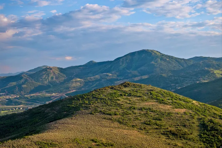 Expansive mountain landscape with rolling, tree-covered hills
