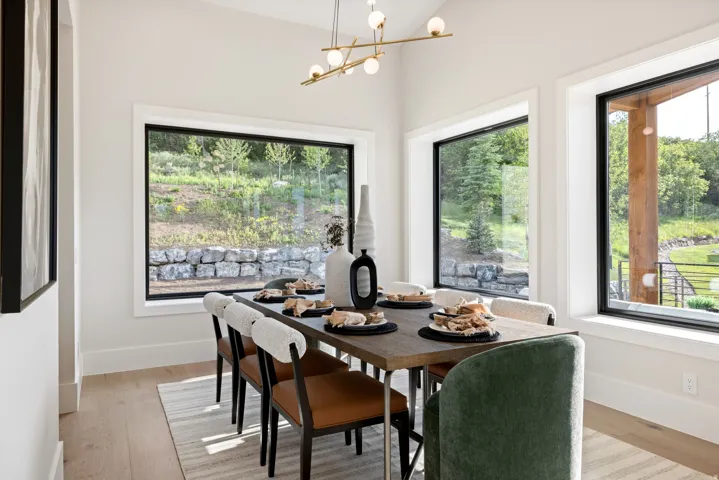Dining area featuring a contemporary linear chandelier and light wood-finish flooring