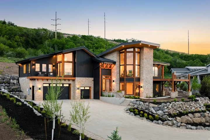 Modern architectural residence featuring extensive stone and dark vertical siding