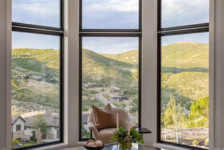 Expansive window wall with multiple large panes framing panoramic mountain and valley scenery