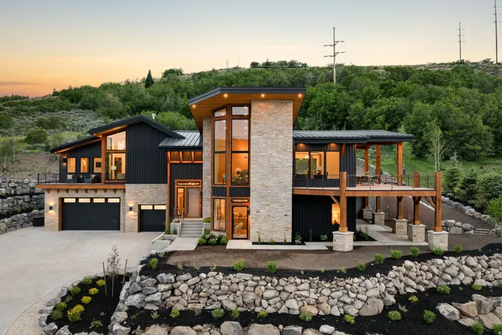 Modern architectural exterior featuring vertical dark siding and stone accents