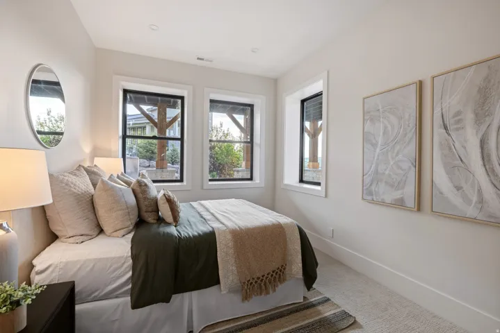 Bedroom featuring three black-framed windows, recessed lighting, light-toned carpeting, and crisp white baseboards