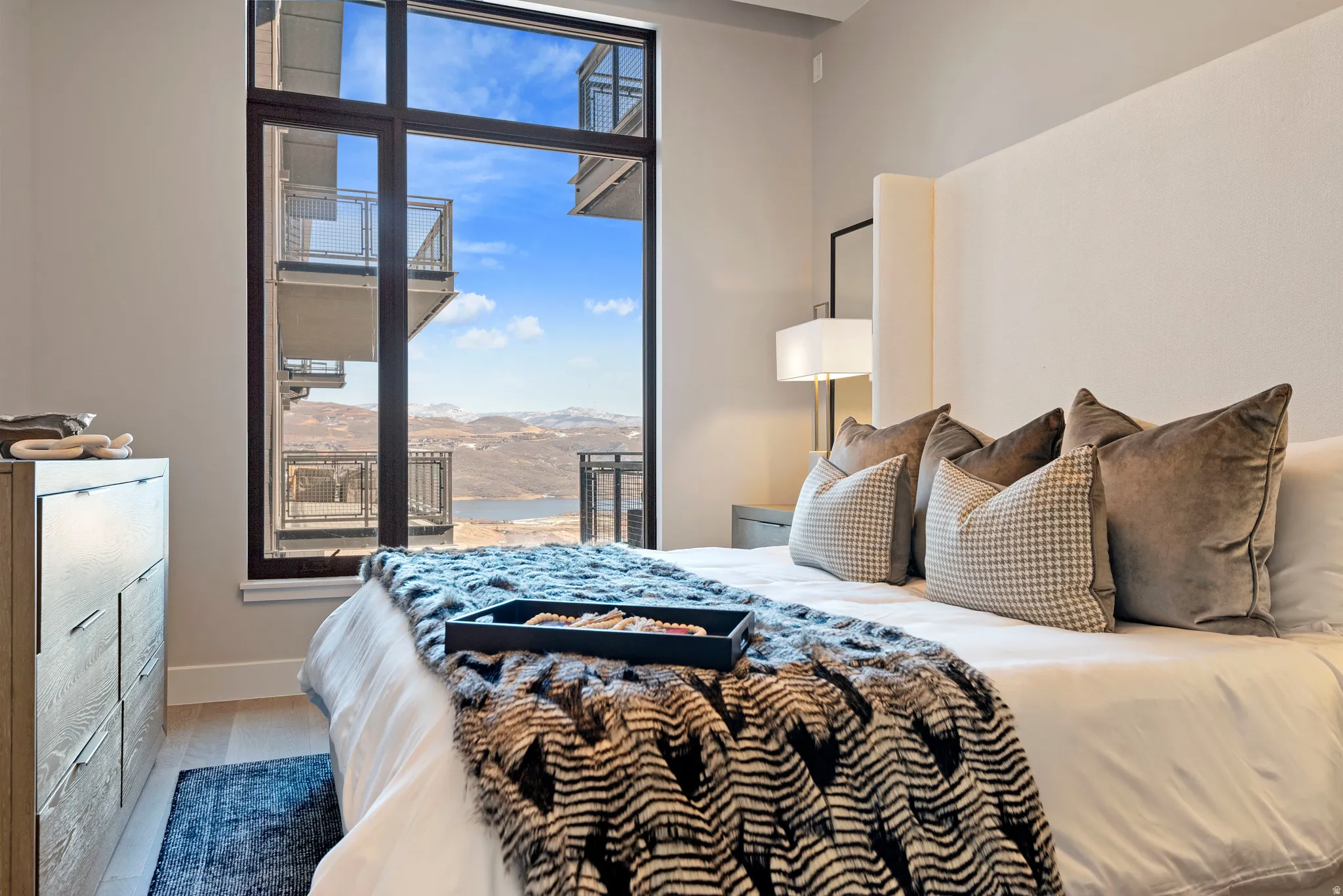 Floor-to-ceiling window offering expansive mountain and lake scenery