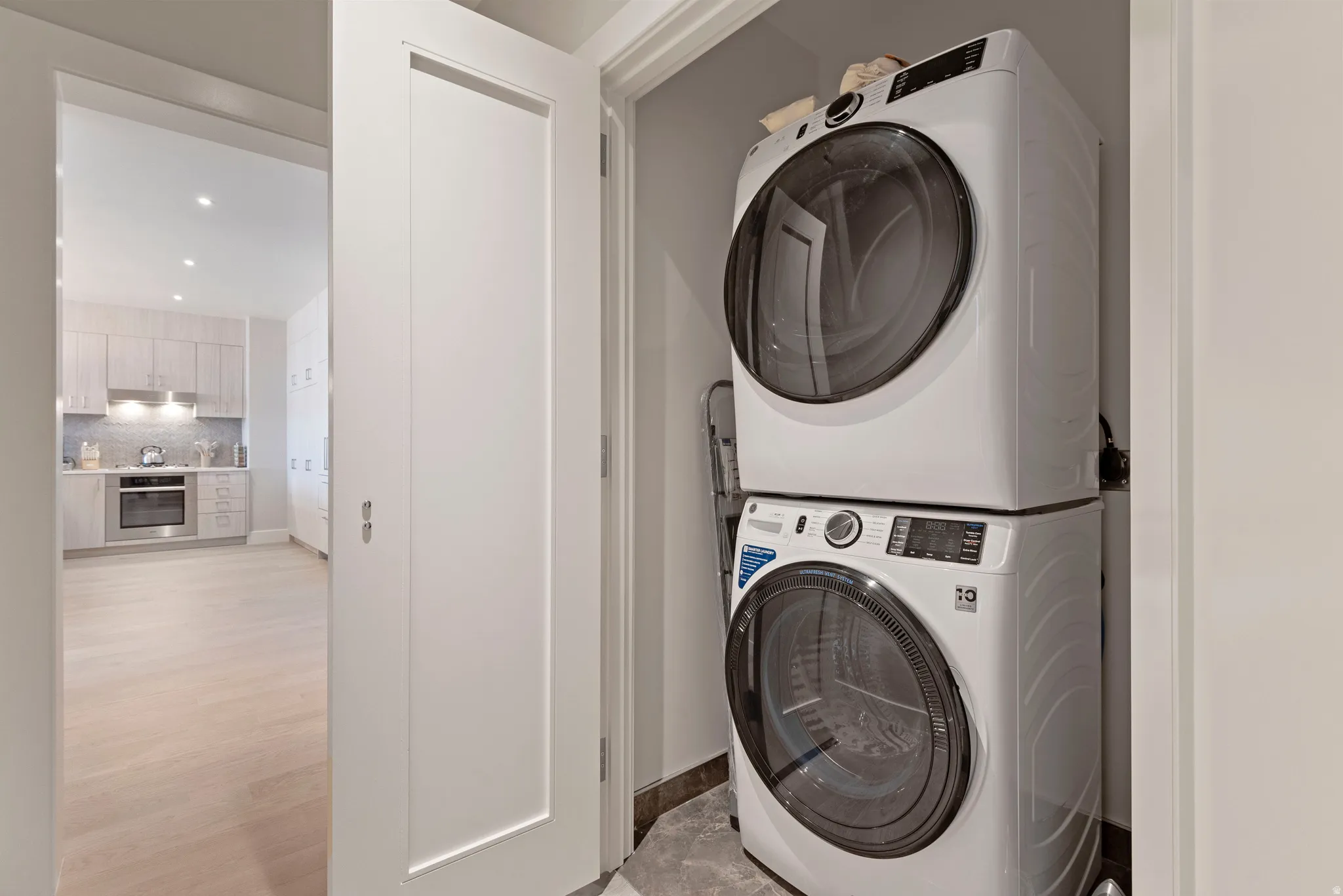 Space-saving stackable washer and dryer appliances within a dedicated utility alcove