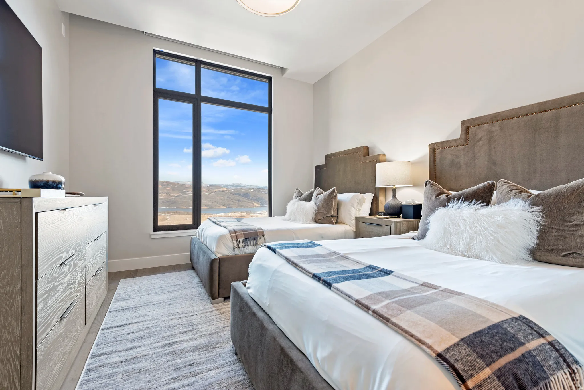 Floor-to-ceiling window showcasing expansive mountain and water scenery