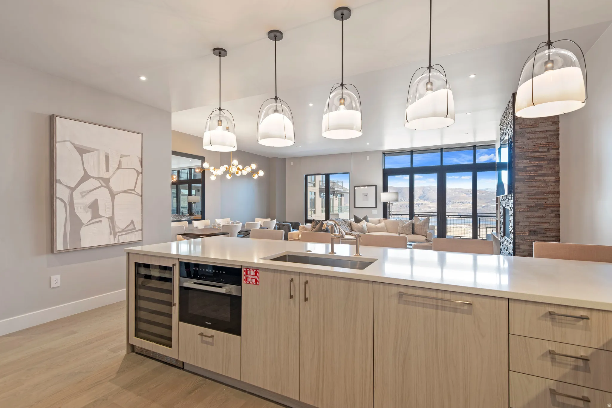 Kitchen island featuring a built-in wine cooler, integrated microwave, and undermount sink with a gooseneck faucet