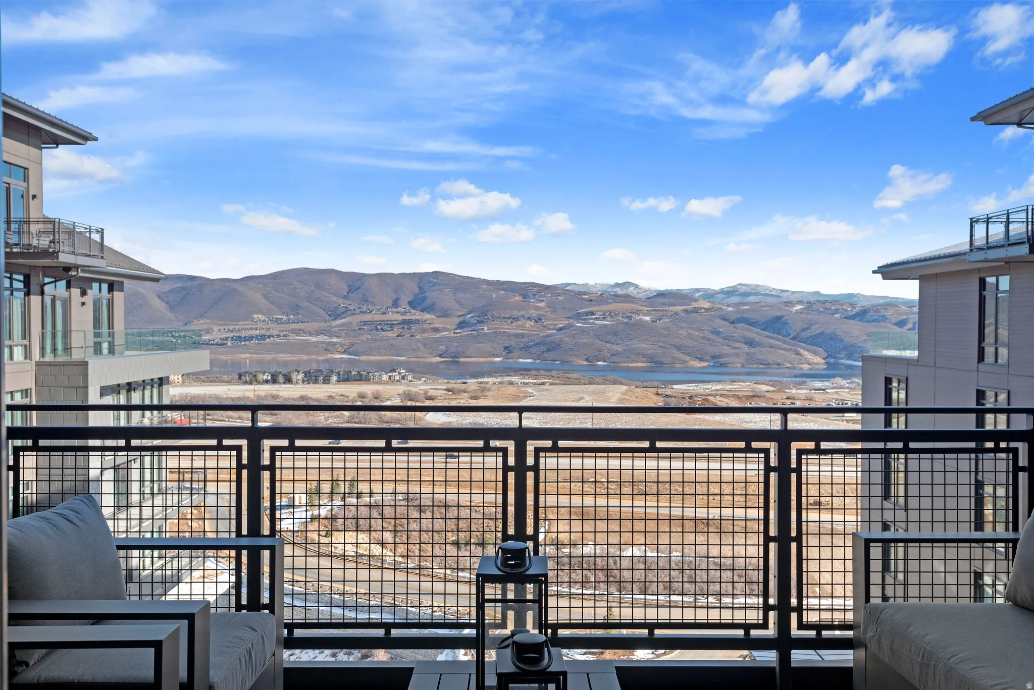 Balcony featuring an open metal railing, offering expansive mountain and water scenery