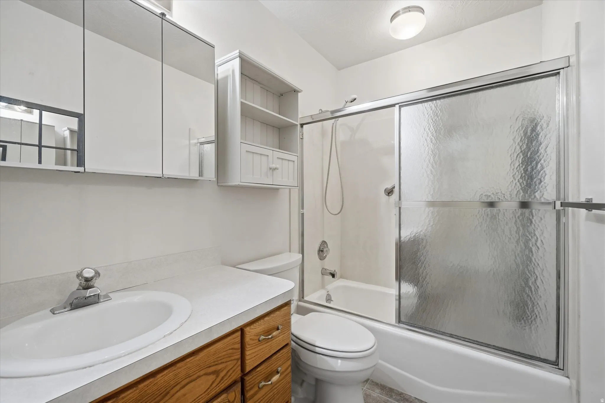 Bathroom vanity with a white countertop and wood-finish cabinetry