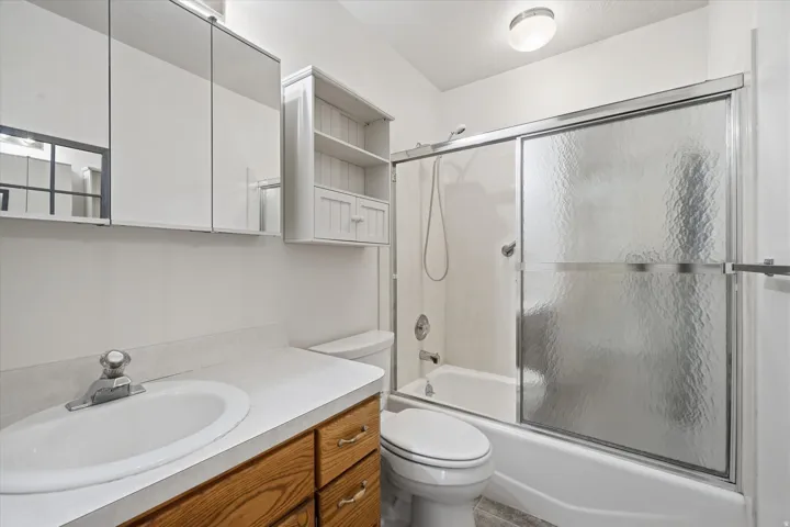 Bathroom vanity with a white countertop and wood-finish cabinetry