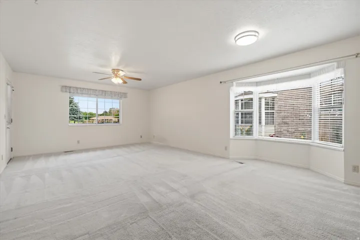 Spacious interior room featuring light-toned carpeting and neutral wall finishes