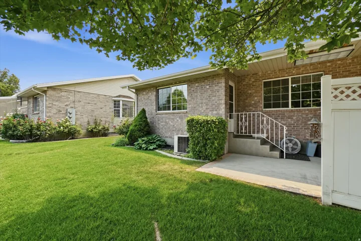 Expansive green lawn with brick exterior and mature landscaping