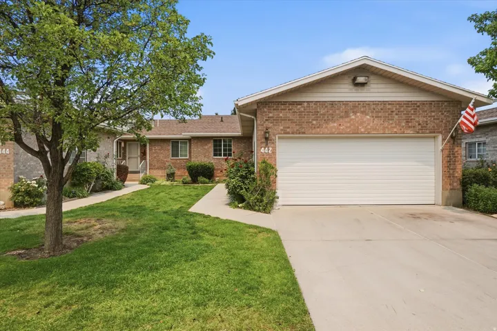 Brick exterior residence featuring an attached garage with a concrete driveway