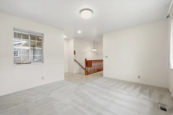 Bright interior space featuring light-colored walls and grey carpeting