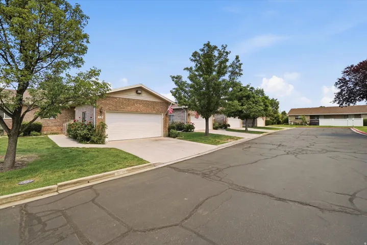 Brick exterior residence with an attached garage, concrete driveway, and front walkway