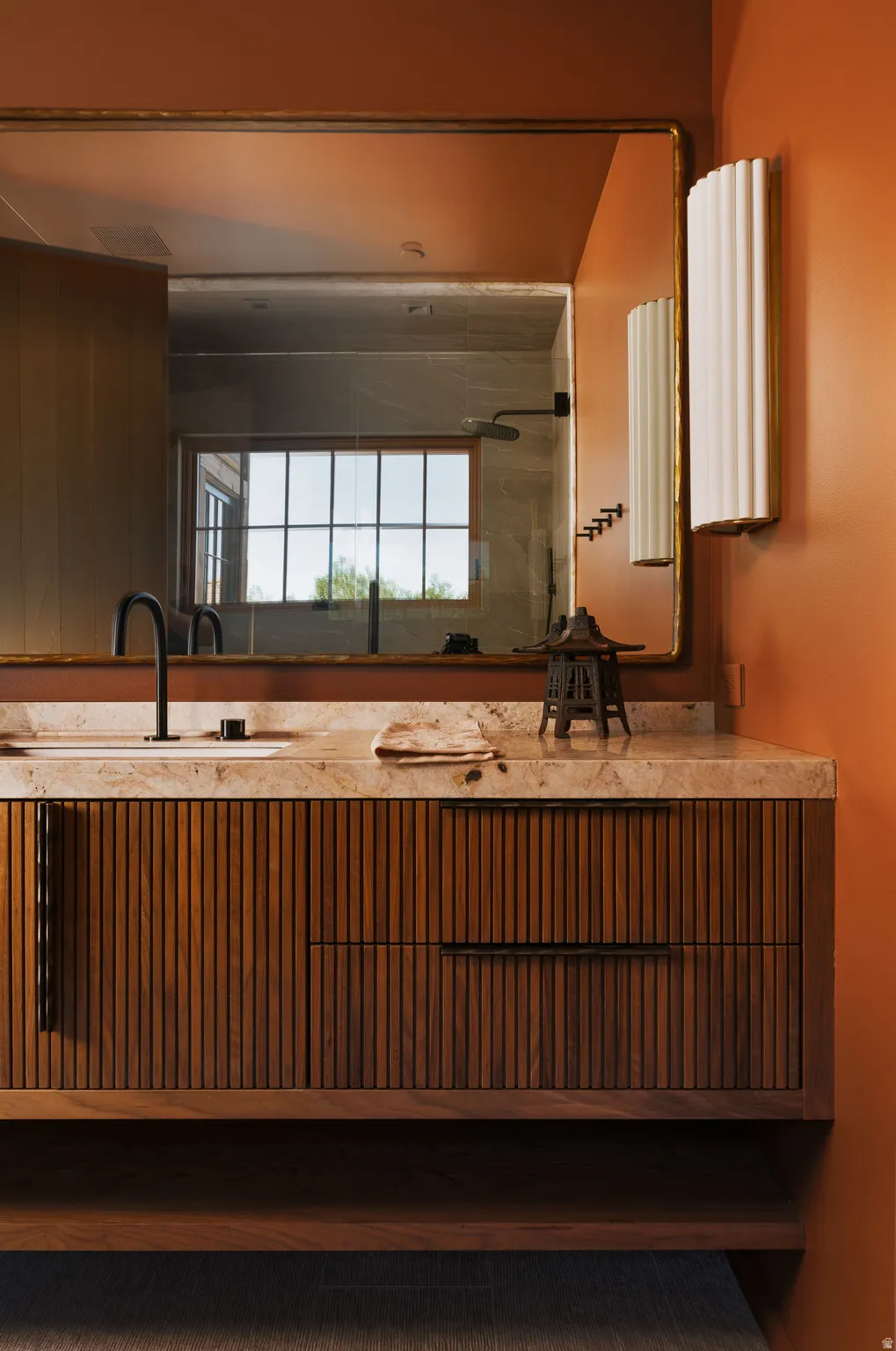 Floating wood vanity with fluted paneling and dark hardware