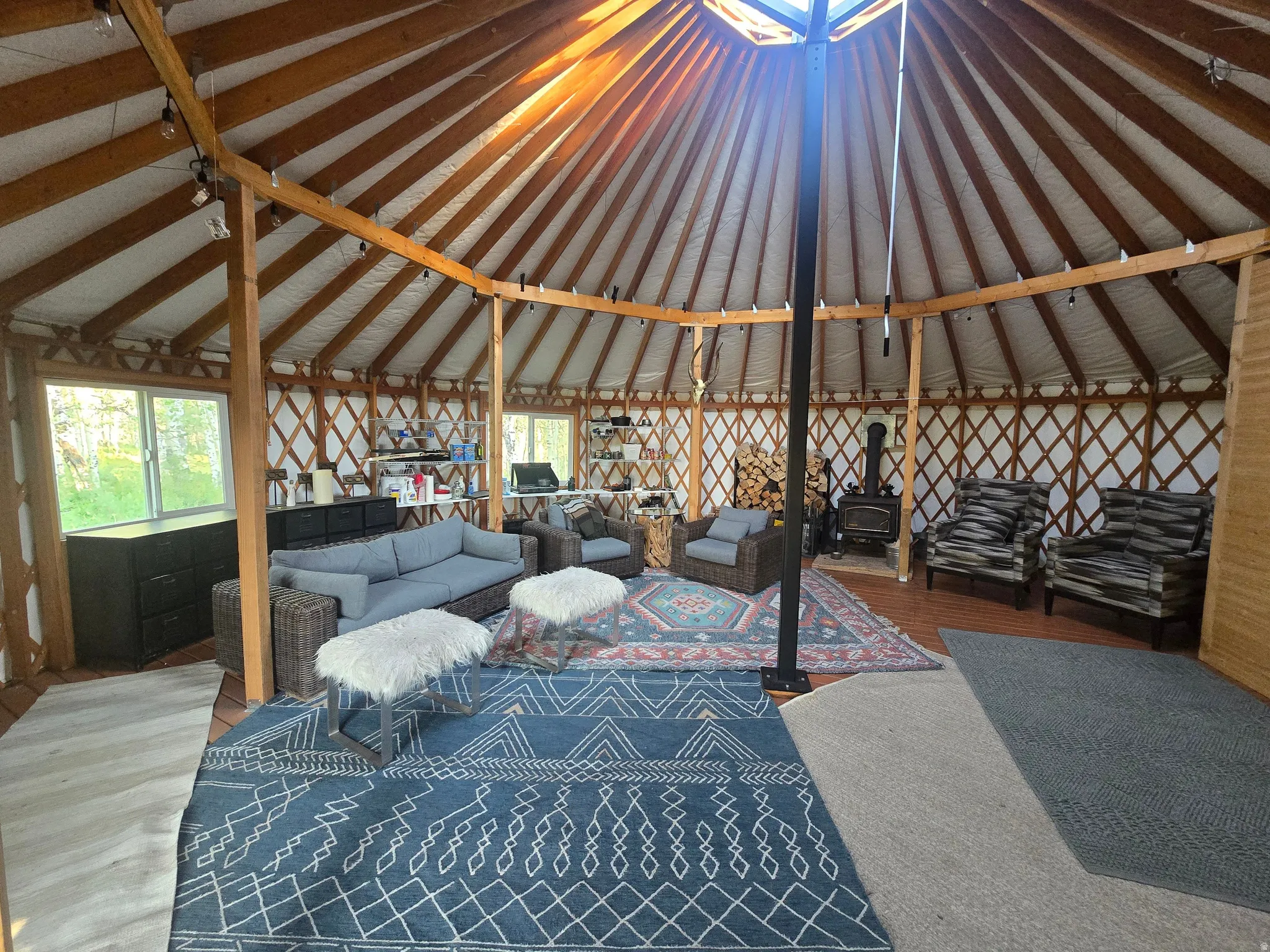 Open-concept living space featuring a wood-burning stove and a central skylight