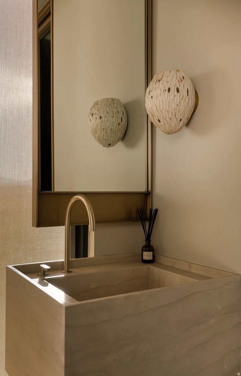 Integrated stone basin with a wall-mounted brass faucet