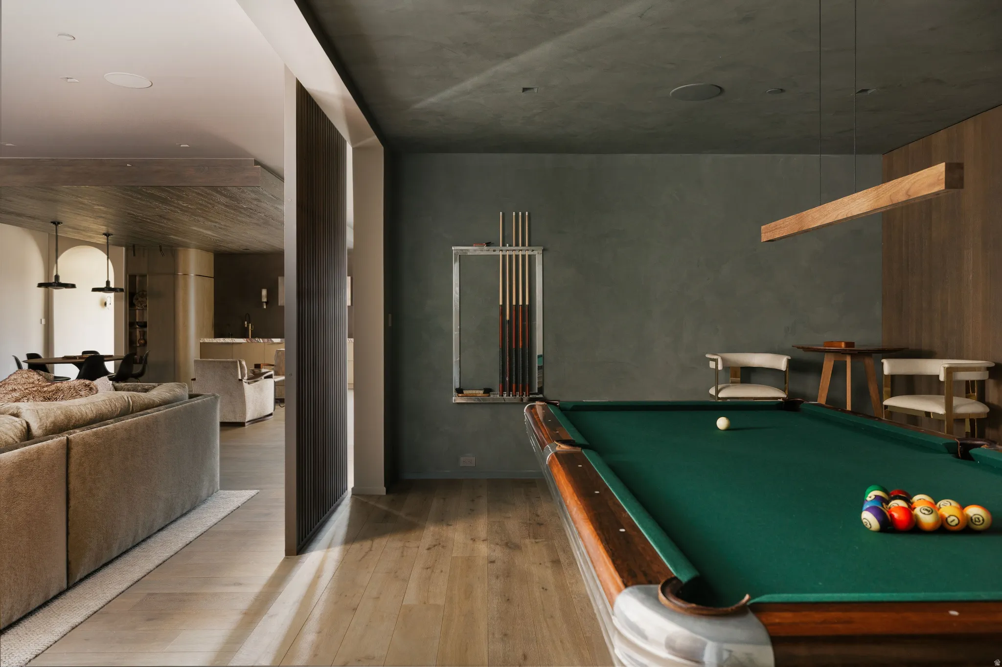 Entertainment room featuring a billiards table with a green felt surface and wood-finish trim, wood-finish flooring, textured wall finishes, and a contemporary linear pendant light