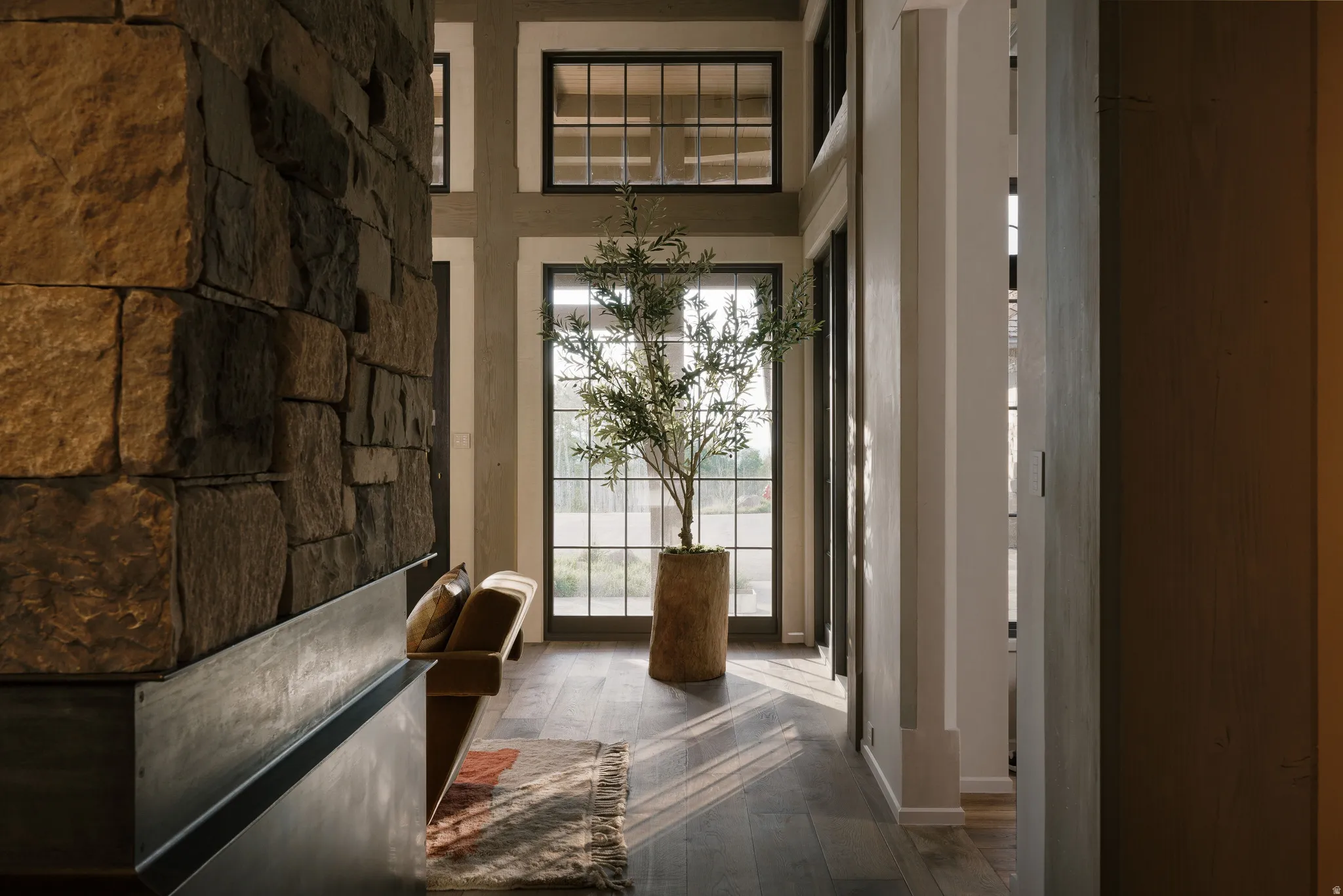 Interior hallway featuring a stacked stone wall with a metal base