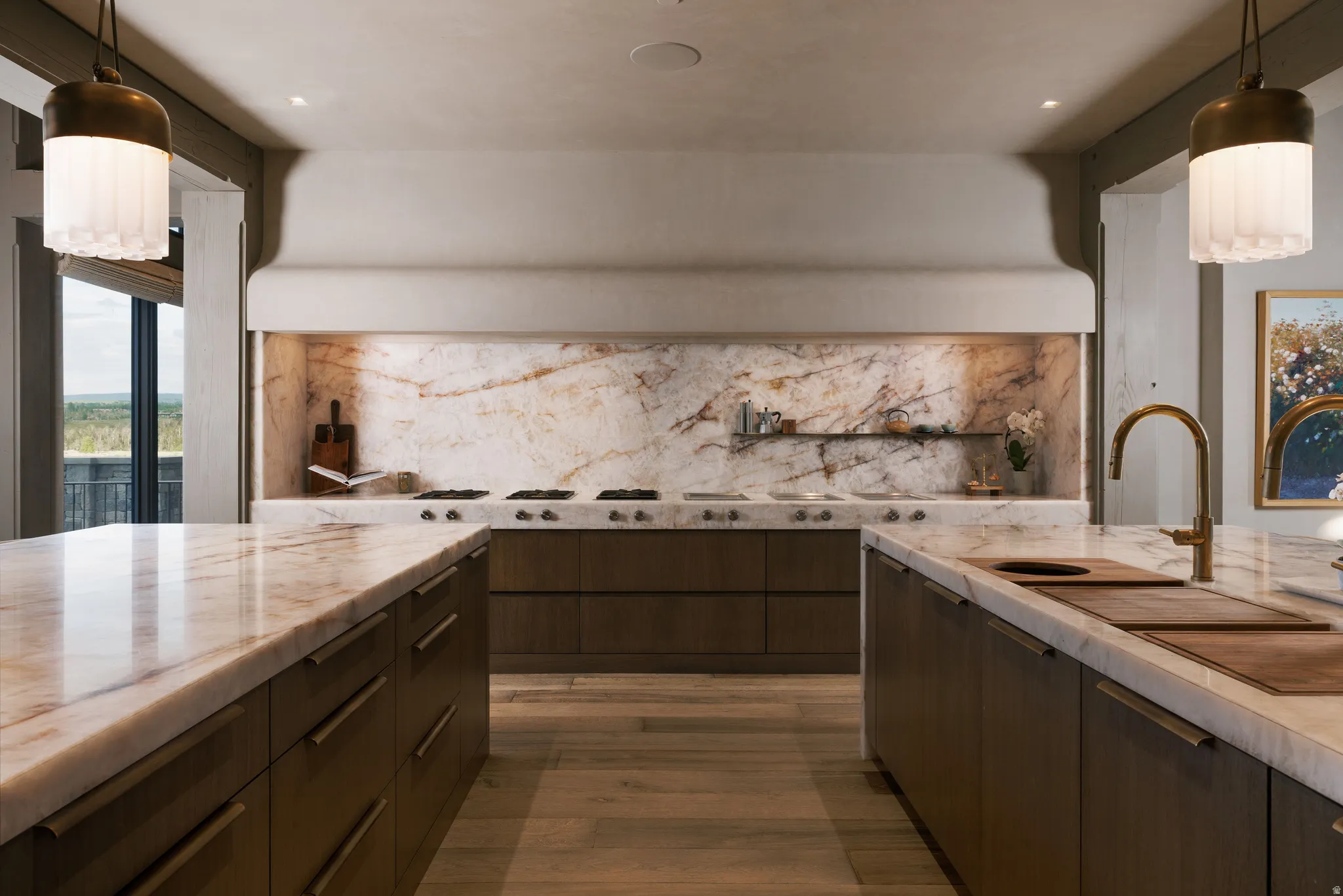 Gourmet kitchen featuring a stone backsplash with integrated shelving, a professional-grade range, dual islands with stone countertops, and a built-in sink with a gooseneck faucet