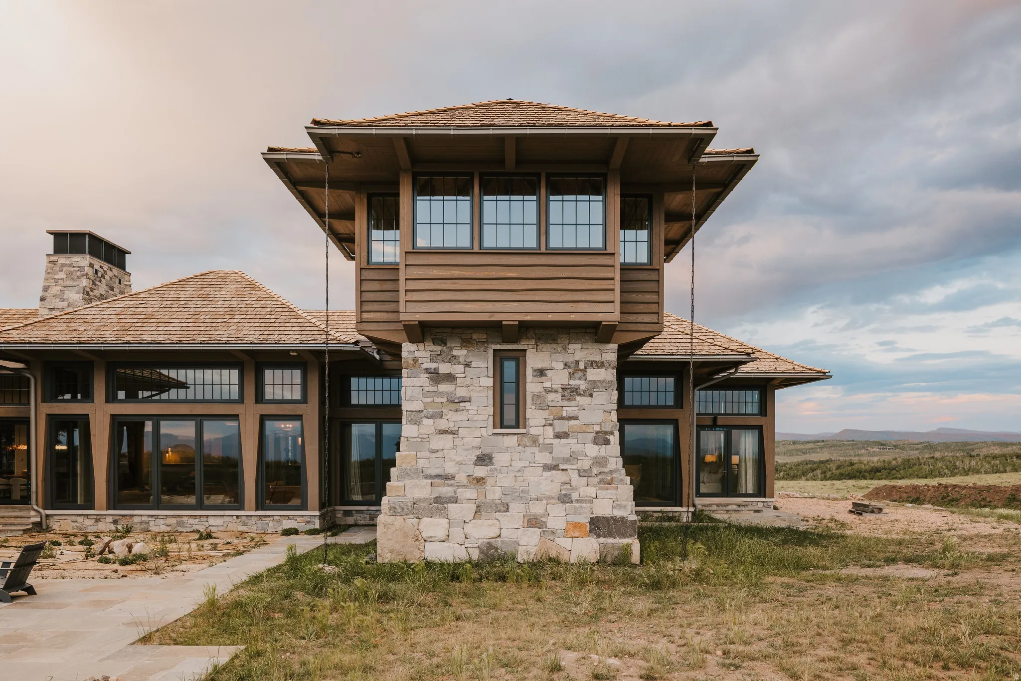 Architectural stonework exterior featuring a distinct tower structure with multi-pane windows