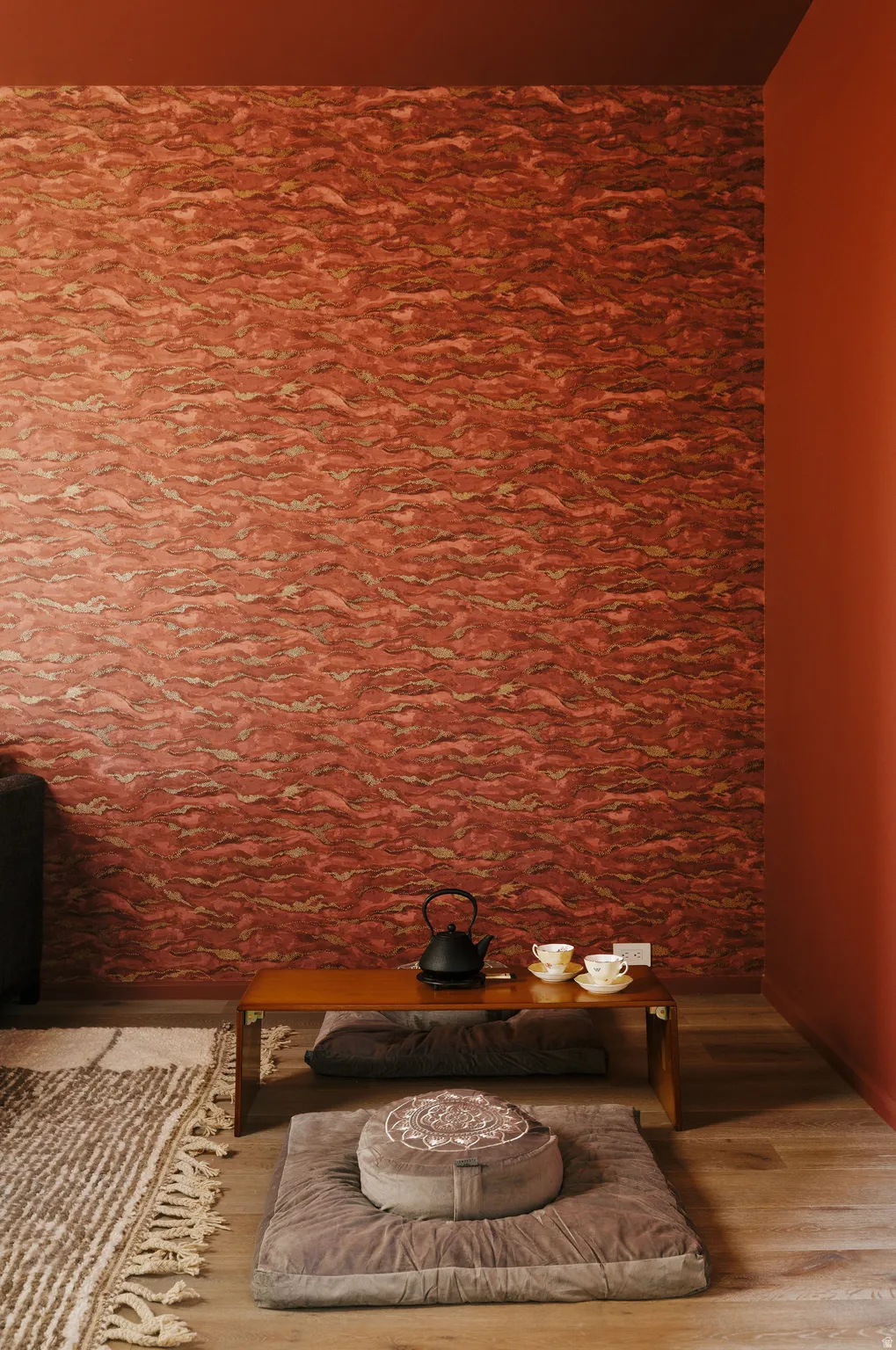 Accent wall with textured red finish, complemented by solid red painted walls and ceiling