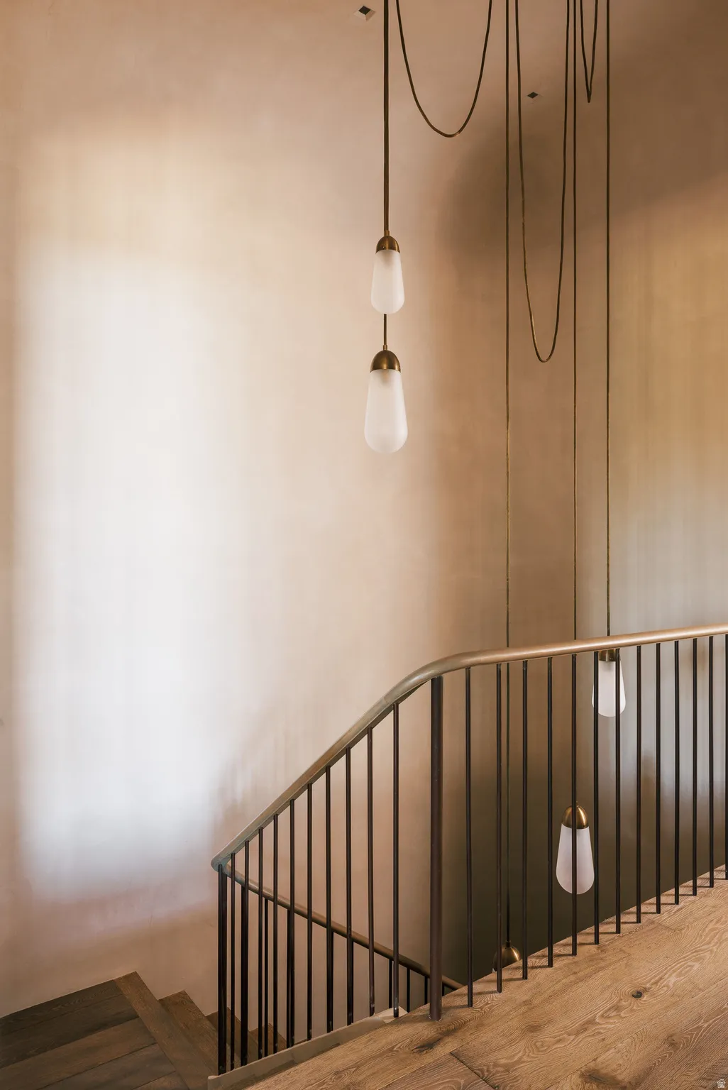 Hardwood stairs featuring a metal railing with vertical balusters