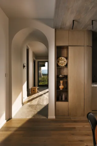 Hardwood flooring extending to an arched hallway with recessed lighting