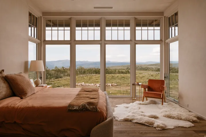 Expansive floor-to-ceiling windows featuring transoms overlooking a mountainous landscape