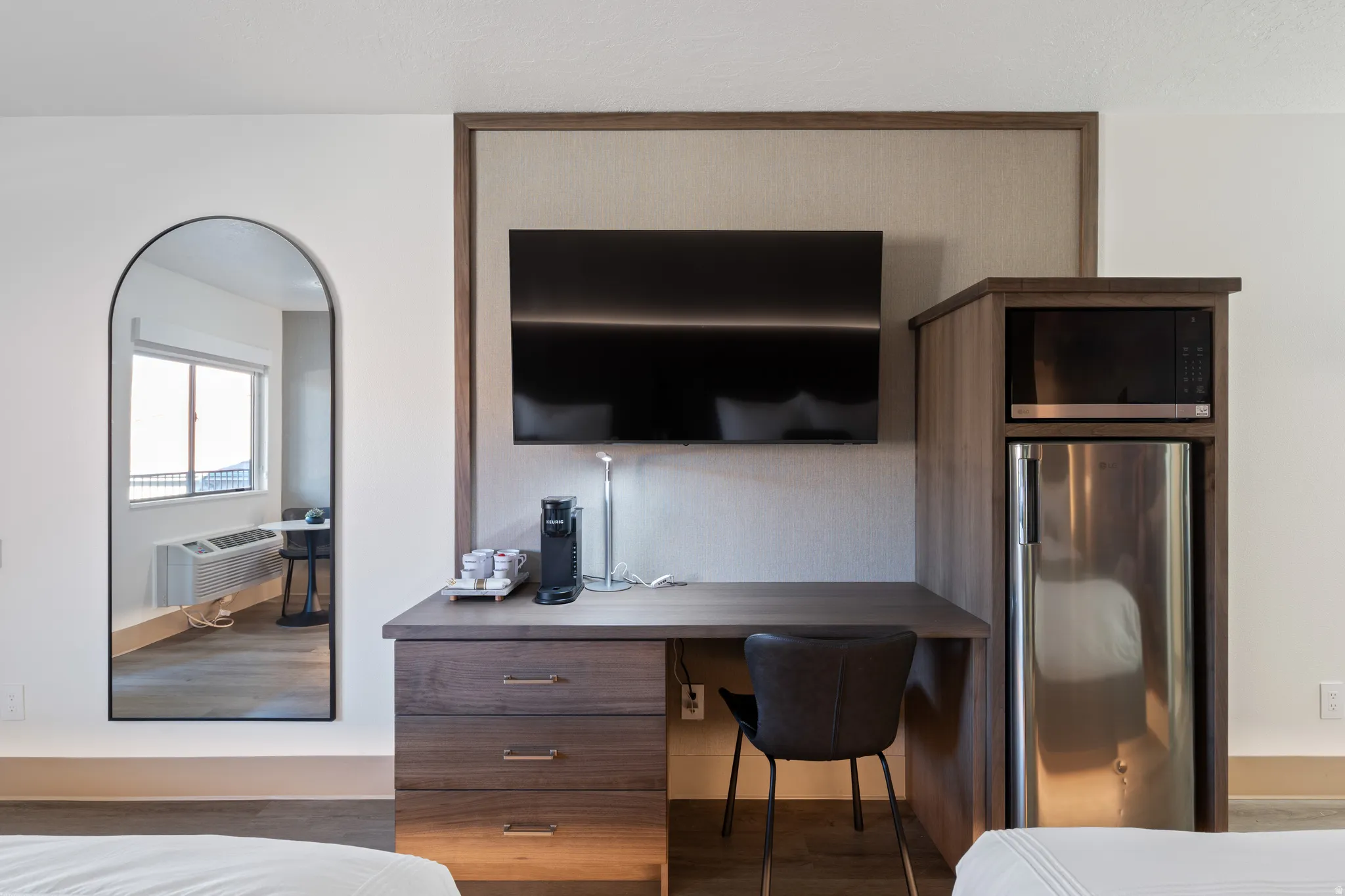 Integrated workstation with wood-finish cabinetry, a built-in stainless steel microwave, and a compact refrigerator