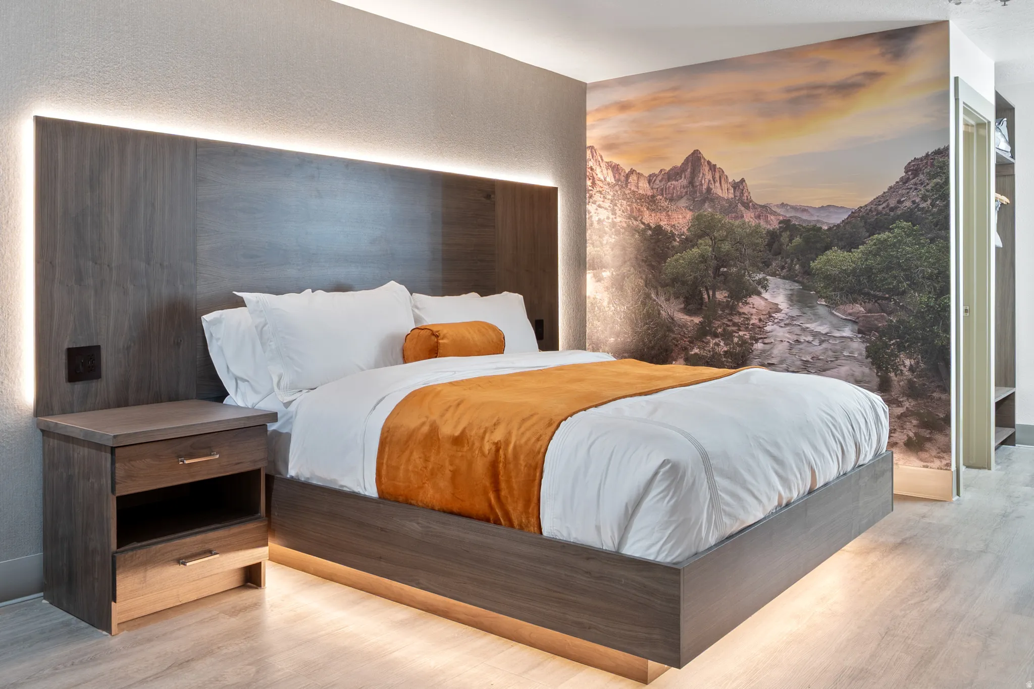 Bedroom featuring a wood-finish platform bed with integrated lighting, a coordinating wood-finish headboard with indirect lighting, and a wood-finish nightstand