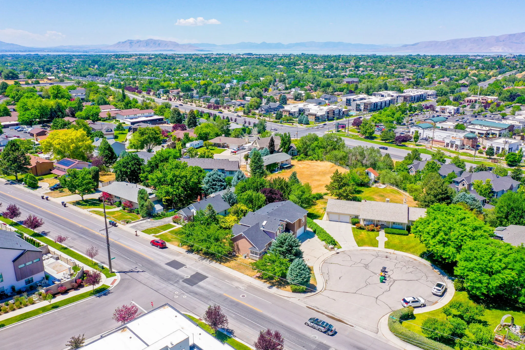 Expansive residential area featuring established homes, mature trees, and a distant mountain range