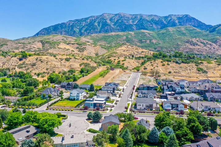 Expansive mountain range backdrop framing a residential area with diverse architectural styles, including contemporary and traditional designs
