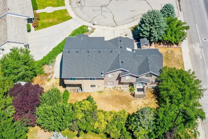 Multi-level residence featuring a gray shingle roof and a light brown siding exterior