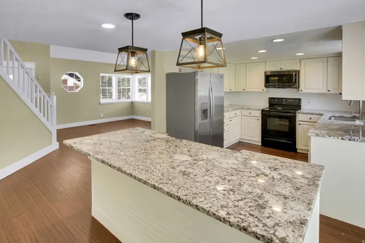 Kitchen island featuring a substantial granite countertop