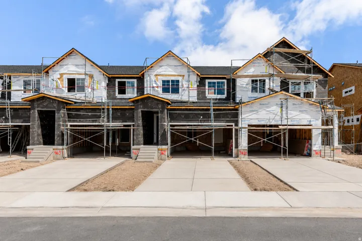 New construction townhomes featuring individual garages and concrete driveways