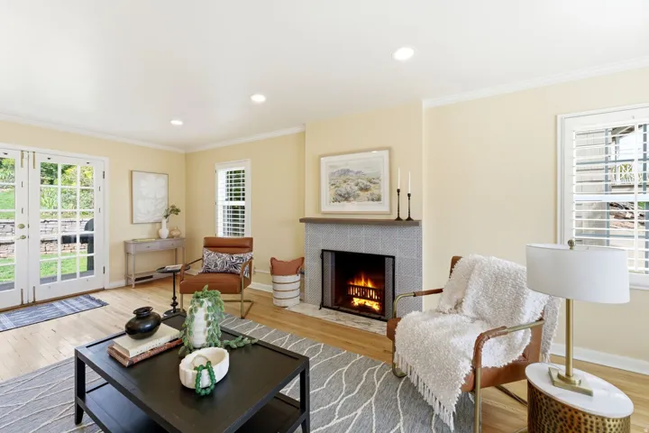 Living space featuring wood-finish flooring and a tiled fireplace with a mantel