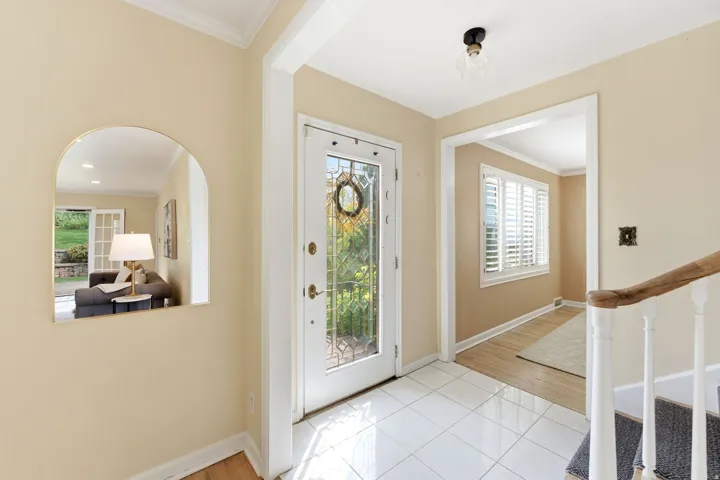 Tiled entryway with a decorative glass front door