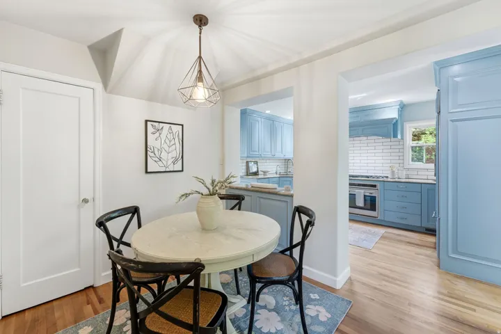 Dining area featuring hardwood flooring and a geometric pendant light fixture